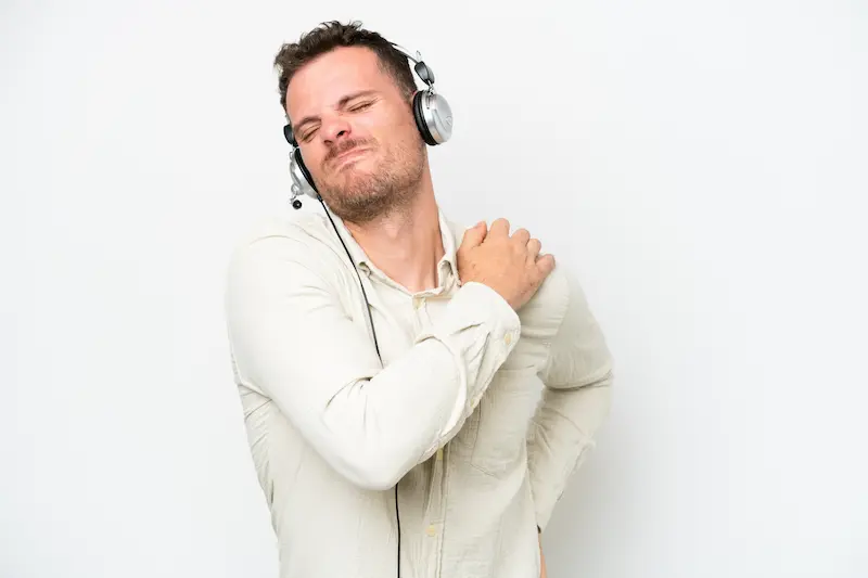 telemarketer-caucasian-man-working-with-headset-isolated-white-background-suffering-from-pain-shoulder-having-made-effort (1)